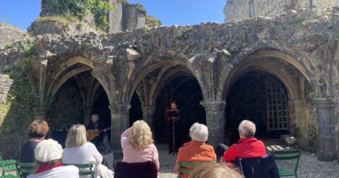 Valérie Aubert (compagnie Calliope) faisant lecture des lais de Marie dans la crypte du château médiéval de Bricquebec, à l'occasion de Pierres en lumières (mai 2025).