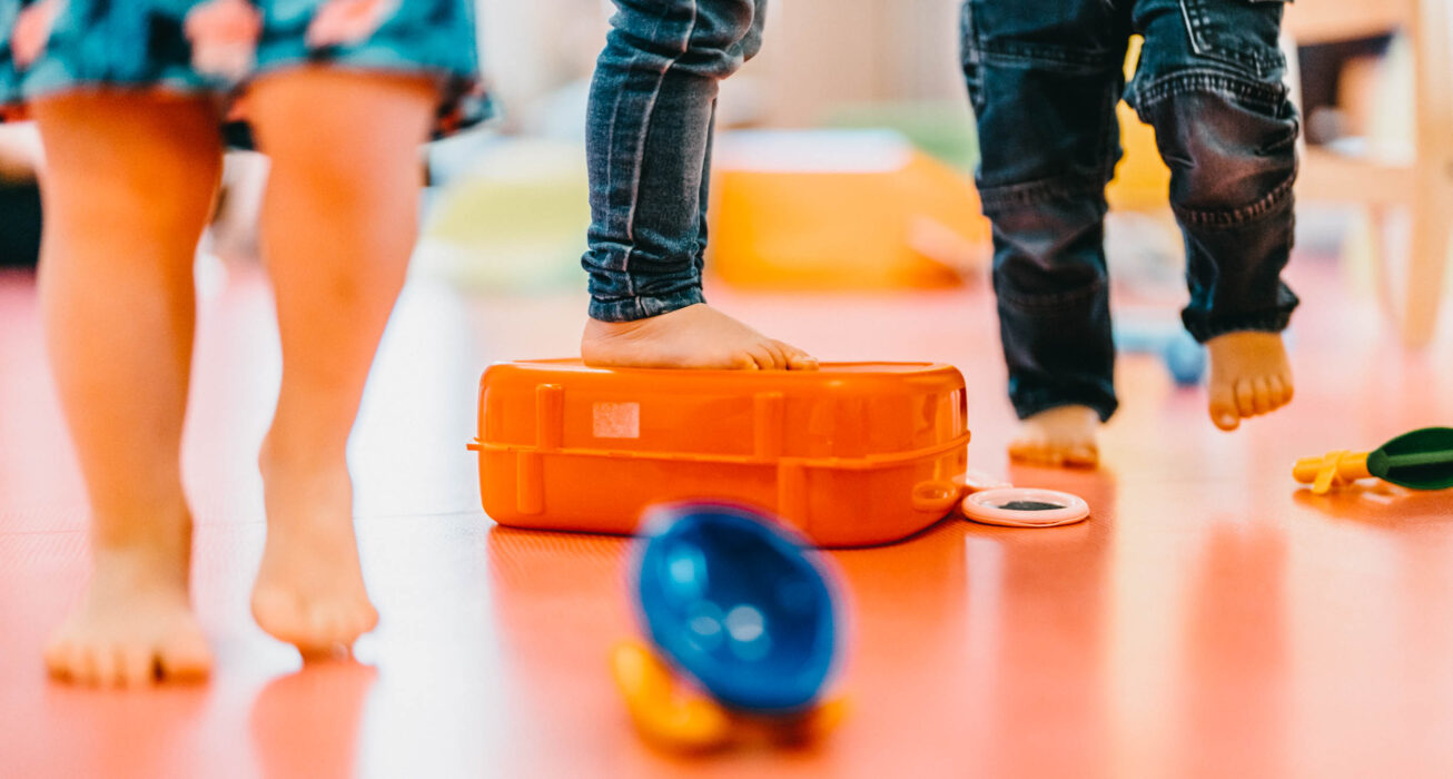 Pieds d'enfants en bas âge posés sur une caisse dans une crèche, illustrant la santé et le quotidien de la petite enfance à Cherbourg-en-Cotentin