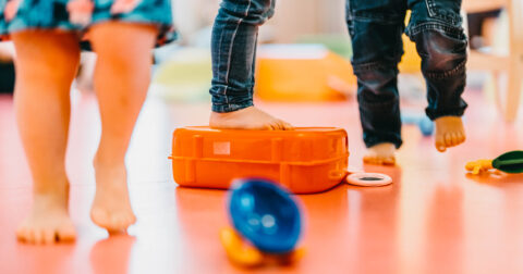 Pieds d'enfants en bas âge posés sur une caisse dans une crèche, illustrant la santé et le quotidien de la petite enfance à Cherbourg-en-Cotentin