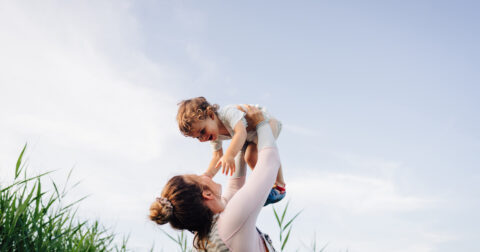 Femme portant son enfant, les deux rigolent